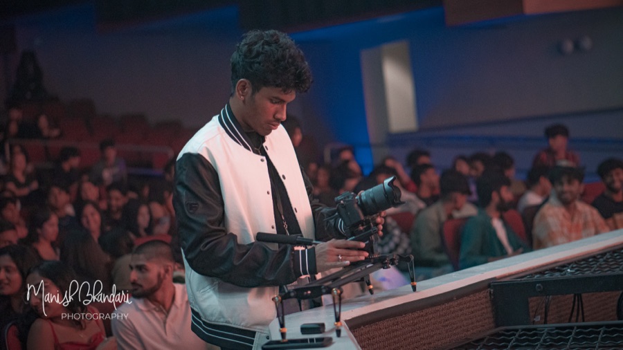 Ashwin Suresh filming with a camera rig at a live event