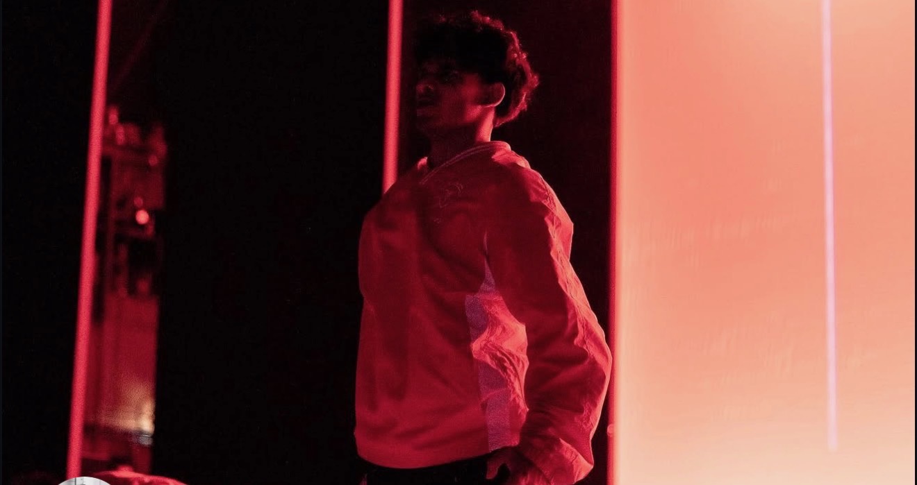 Dancer performing on a red-lit event stage