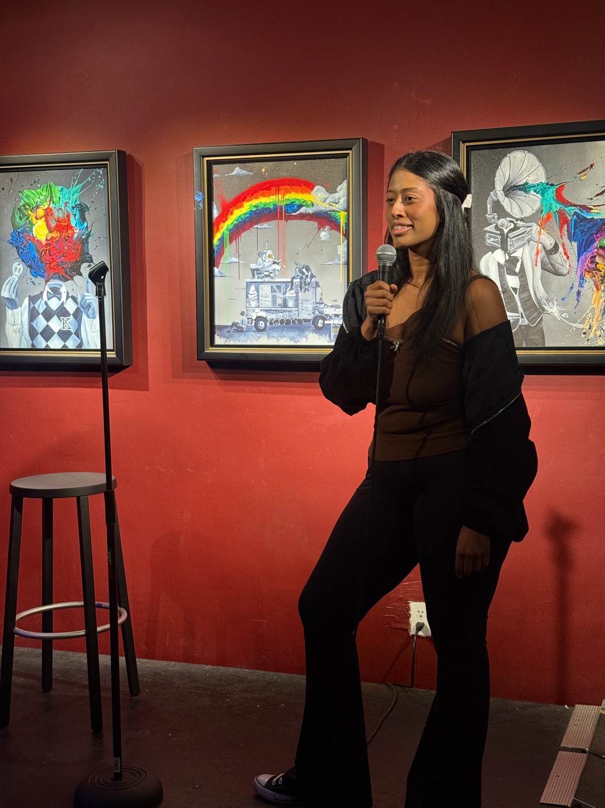 Sesha performing comedy with a microphone